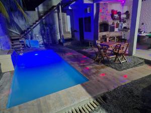 a swimming pool in a backyard with a table and chairs at Quarto duplo ventilador in Conde