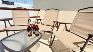 due bottiglie di birra appoggiate su un tavolo con sedie di Casa privada a 5min del Puente de cristal con terraza, BBQ, jardín y parking a Zacatlán