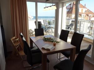 a dining room with a table and chairs and a balcony at Ostseebrise 14 - Großenbrode in Grossenbrode