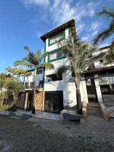 Un edificio blanco con palmeras delante. en Hotel Pousada Getsemani, en Mariana