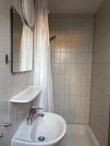 a bathroom with a sink and a tub and a mirror at City Nest Ettlingen - nähe Wasenpark in Ettlingen +23 photos