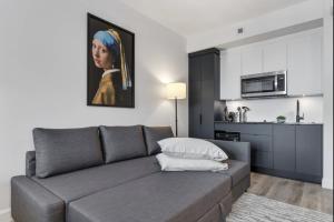 a living room with a couch and a painting of a woman at INITIAL - SUITE JOCONDE - Centre-Ville de Québec in Quebec City