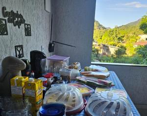 a table with plates of food on top of it at Casa tia Rosa, hospedagem familiar Guapimirim RJ in Guapimirim