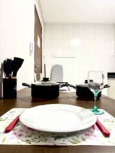 a plate and a wine glass on a table at Studio Charmoso e Aconchegante em Itaberaba II in Itaberaba +13 photos