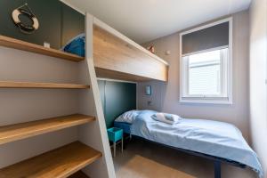 a small bedroom with bunk beds and a bed at Boje 73 in Scharbeutz
