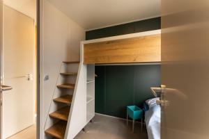 a small bedroom with a bunk bed and green walls at Boje 73 in Scharbeutz