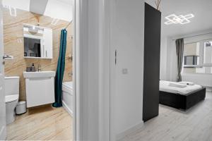 a bathroom with a sink and a bed in a room at Minimalist Green & Grey Flat in Bucharest +18 photos