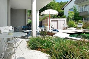 a patio with a table and chairs and a pool at Bodensee-Apartment SeeSucht No 86 in Bodman-Ludwigshafen