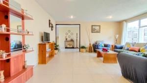 un soggiorno con un divano e una TV di Casa privada a 5min del Puente de cristal con terraza, BBQ, jardín y parking a Zacatlán