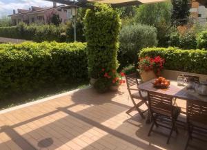 a patio with a table and chairs and bushes at Liguorini House in Avellino