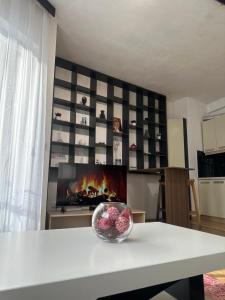 a living room with a fireplace and a bowl of fruit on a table at BT Apartments 2 in Pristina