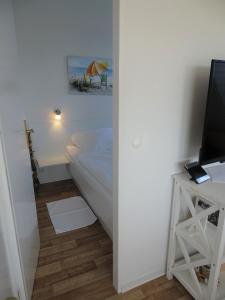 a small bedroom with a bed and a television at Haus Wildfang FeWo 2 in Dahme