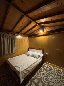 a bed in a room with a wooden ceiling at Mangrove Camp in Sharm El Sheikh