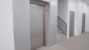 a hallway with white walls and a door and stairs at Beck's Place in Chaguanas +4 photos