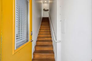 a stairway with yellow walls and a yellow door at Modern Townhome 2 Miles South of Downtown and Broadway Ave in Nashville