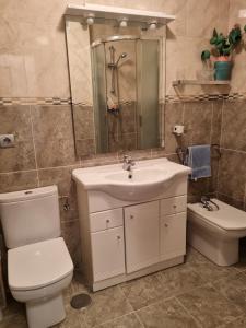 une salle de bain avec des toilettes blanches et un lavabo dans l'établissement flat right on the beach with a view, à Suances 22 autres photos