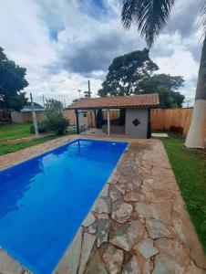 a large blue swimming pool in front of a house at Área de lazer camping in São Carlos