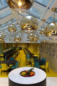 فندق ثون تيرمينوس في أوسلو: غرفة طعام بها طاولات وكراسي وثريات