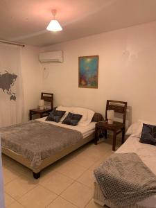 a bedroom with two beds and two tables at Maison Centre-ville Mer à pied in Saint-François +2 photos