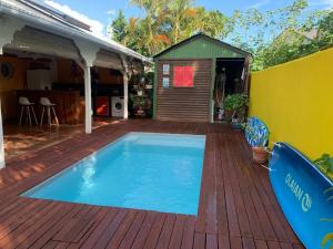 a small swimming pool on a wooden deck at Maison Centre-ville Mer à pied in Saint-François