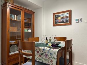 a dining room table and chairs with a table and a cabinet at San Miguel in Almería