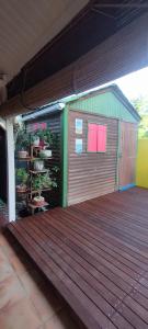 a wooden deck with a building with a door at Maison Centre-ville Mer à pied in Saint-François