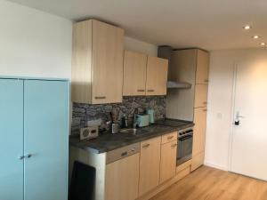 una cocina con armarios de madera y una pared de piedra. en Apartment Tälerblick 2, neu modernisiert, en Böbrach