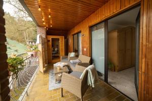 Un patio con sillas y un sofá en un balcón. en Ferienwohnung Engelsblick, en Kreuzau