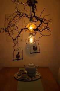 a chandelier with a tea pot and cups on a table at Hof Timmermann - Spatzennest in Ottenstein +7 photos