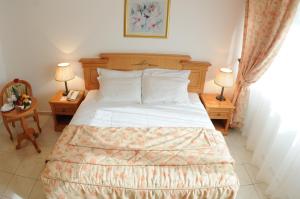 a bedroom with a bed with two tables and two lamps at Uptown Hotel Apartments Abu Dhabi in Abu Dhabi