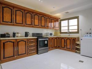 a large kitchen with wooden cabinets and a refrigerator at أزهار طيبة in Al Madinah