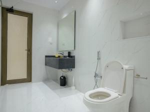 a white bathroom with a toilet and a sink at أزهار طيبة in Al Madinah +38 photos