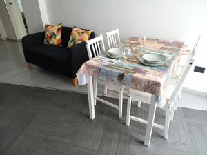 a dining table and chairs with a table and a couch at La Casa di Saretta in Trieste