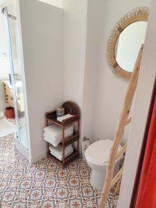 a bathroom with a toilet and a mirror at Casa Louisa in Serralongue