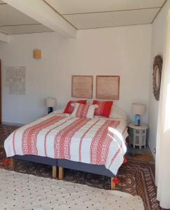 a bedroom with a large bed with red pillows at Casa Louisa in Serralongue