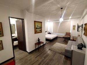 ein Wohnzimmer mit einer Couch und einem Bett darin in der Unterkunft Hotel Museo San Moritz in Bogotá + 37 Fotos