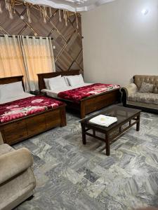 a room with two beds and a couch and a table at AWARI in Guest House in Hyderabad