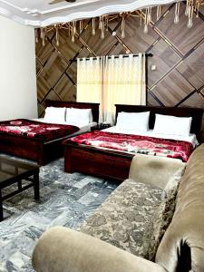 a bedroom with two beds and a couch at Avaari Inn Guest House in Hyderabad