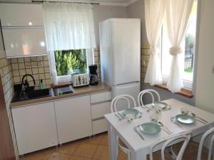 a kitchen with a white refrigerator and a table with chairs at Holiday Home near Baltic Sea & Sandy Beaches in Międzyzdroje