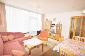 una sala de estar con un sofá y una mesa en Ferienbungalow 3, en Dahme