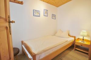 Un pequeño dormitorio con una cama y una lámpara en una mesa. en Ferienbungalow 3, en Dahme