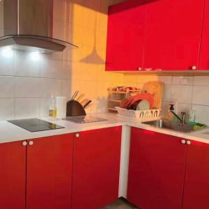 a kitchen with red cabinets and a sink at Cozy shared home for female in Stockholm in Stockholm