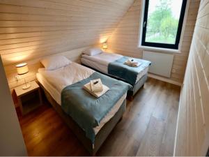 two beds in a small room with a window at House in Stepnica near Szczecin Lagoon in Stepnica