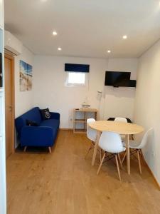 a living room with a blue couch and a table at Herama Sea Guesthouse in Vila Nova de Gaia