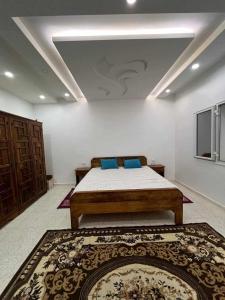 托泽尔Maison Chebbi的卧室里有一张床，上面放着蓝色的枕头