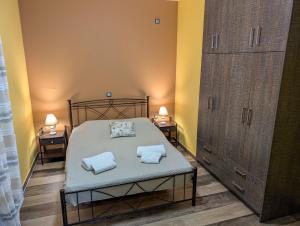 a bedroom with a bed with two towels on it at Dimitris Hidden Paradise - Three bedroom apartment in Ayía Iríni