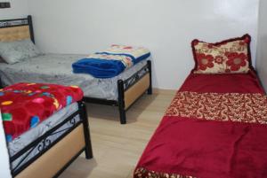 a room with two beds and a bed and a couch at Magnifique chambre à prix inedit in Agadir