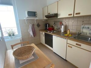 a kitchen with a sink and a table with a sink at Haus AchternDiek Strandvogel in Dahme