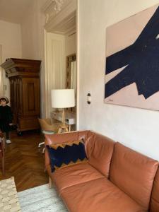 a living room with a brown couch and a painting at ANNO 1800 in Bistriţa +17 photos