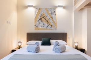 Un dormitorio con una cama blanca con toallas. en Apartment in the old town of Como - MonicaComoApartment, en Como